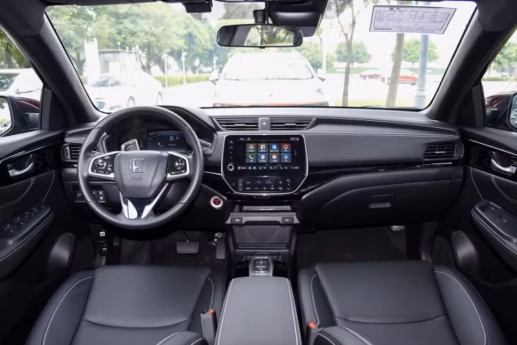 Nẹp mạ crôm kể trên nối liền với cụm đèn pha hai bên. Đèn pha chính của xe được bao quanh bằng dải đèn LED định vị ban ngày. Bên dưới là hốc gió trung tâm hình thang ngược và 2 đèn sương mù hình tròn, nằm trong hốc màu đen. Nhìn chung, thiết kế đầu xe của Honda Crider 2022 tạo cảm giác tròn trịa và đầy đặn hơn trước.