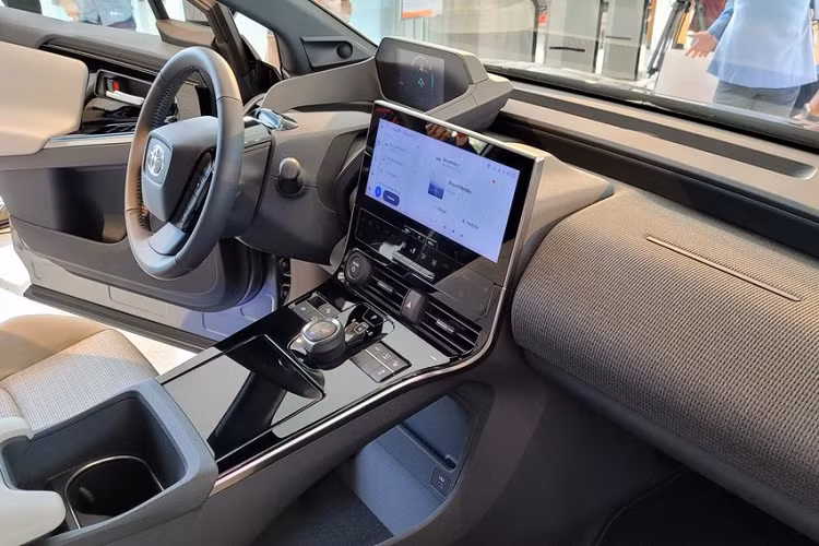 Tiếp đến là cụm đèn pha hình thang với 4 bóng LED vuông vắn, nằm bên dưới dải đèn LED định vị ban ngày hình chữ "L". Cụm đèn pha được tích hợp vào chắn bùn trước màu đen bóng. Vòng sang bên sườn, chúng ta sẽ thấy những đường dập gân sắc sảo, chắn bùn sau nổi bật và ốp màu đen bóng xung quanh hốc bánh. Các cột và nóc của Toyota bZ4X cũng được sơn màu đen bóng.