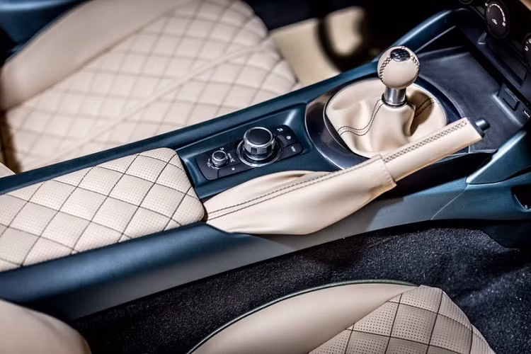 Viền cửa sổ và cụm nút chỉnh gương giả carbon. Hốc để đồ trung tâm khá giống với Mazda MX-5 ND. Các cửa điều hòa hình tròn đặc trưng có viền chrome.