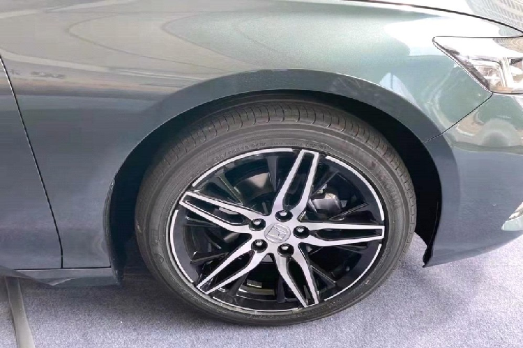 Bên dưới lưới tản nhiệt này là hốc gió trung tâm hình thang tương đối rộng, tích hợp đèn sương mù trước. So với phiên bản cũ, cản trước của Honda Inspire 2022 đã thay đổi thiết kế và có thêm 2 khe gió thể thao hơn ở hai góc. Nhìn từ bên sườn, chúng ta sẽ thấy nẹp mạ crôm mới bên dưới cửa và bộ vành la-zăng 5 chấu kép được sơn 2 màu thể thao. Thiết kế sườn xe của Honda Inspire 2022 gần như giống hệt Accord. 