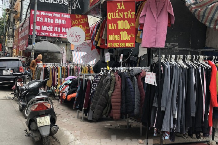 Một cửa hàng trên phố chùa bộc bán áo len đồng giá 80.000 đồng/chiếc; áo phao được "xả" ở mức giá 150.000 đồng/chiếc. Trong ảnh là cửa hàng ở phố Cầu Giấy bán quần tất các loại từ 10.000 - 30.000 đồng, áo len 100.000 đồng/chiếc. Một khách hàng đang mua hàng tại phố Cầu Giấy cho biết: "Cùng một mặt hàng như nhau, mua vỉa hè chỉ từ 100.000 - 200.000 đồng/chiếc, nhưng nếu vào shop có khi sẽ có giá 500.000 đồng do chi phí thuê cửa hàng, thuê người bán khiến giá sản phẩm bị đội cao. Vì thế, tôi chịu khó mua vỉa hè, giá thành rẻ mà vẫn đẹp như mua ở shop".