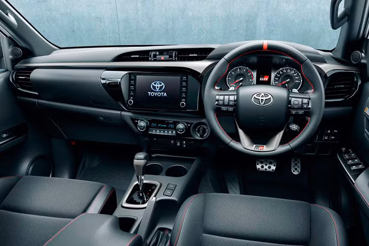 Ở bên trong, hàng ghế lái thiết kế thể thao được bọc bằng da tổng hợp với logo GR nổi bật thêu trên tựa đầu. Vô lăng 3 chấu bọc da tối màu với đường chỉ khâu màu đỏ nổi bật cùng logo GR ở đáy. Ngoài ra, nút bấm khởi động, màn hình công cụ kỹ thuật số và chìa khóa cũng có logo GR.