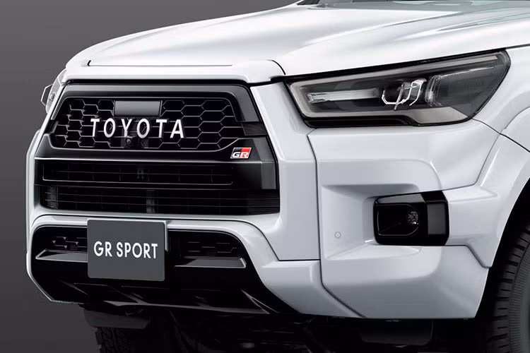 Bộ lưới tản nhiệt của Toyota Hilux GR Sport 2022 đi kèm khung mới và các tấm ốp vè bánh xe sơn cùng màu thân xe (với đường viền màu đen). Cản va trước cũng được thiết kế lại với lớp sơn hoàn thiện màu trắng, trong khi viền đèn sương mù trông tinh tế hơn so với phiên bản phân phối tại Thái Lan.