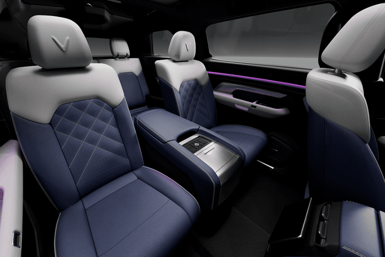 Đáng chú ý, hàng ghế thứ 2 của VinFast VF e36 là loại ghế thương gia với tựa đầu có dập logo chữ “V” của hãng xe Việt. Ở chính giữa là bệ tì tay khá lớn, nhiều khả năng có hộp làm mát và ngăn để cốc.