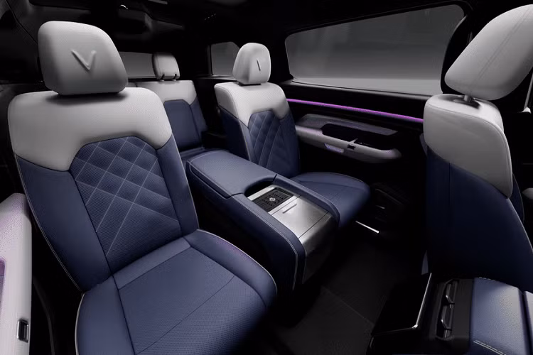 Đáng chú ý, hàng ghế thứ 2 của VinFast VF e36 là loại ghế thương gia với tựa đầu có dập logo chữ “V” của hãng xe Việt. Ở chính giữa là bệ tì tay khá lớn, nhiều khả năng có hộp làm mát và ngăn để cốc.