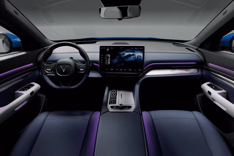 Nội thất của VinFast VF e36 cũng có nhiều điểm tương đồng với đàn em VF e35 nhưng sử dụng tông màu xanh là chủ đạo phối hợp cùng màu đen. Phía sau vô lăng của xe cũng không có bảng đồng hồ và nhiều khả năng thông tin sẽ được hiển thị trên màn hình kính lái dạng HUD hoặc màn hình lớn ở khu vực trung tâm. Phía bên dưới, xe được trang bị nút bấm chuyển số tạo cảm giác tối giản về mặt thiết kế.