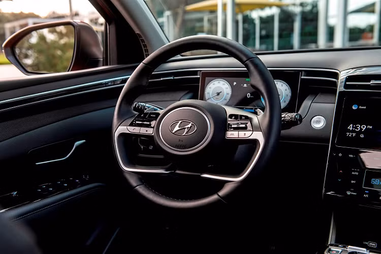 Vô lăng mới của Tucson được bọc da và thiết kế khá độc đáo với hai tông màu bạc/đen. Thay thế cho cụm đồng hồ dạng analog nằm phía sau vô lăng là một màn hình kỹ thuật số có khả năng hiển thị đầy đủ các thông số vận hành quan trọng. Tucson 2022 nhận được gói trang bị an toàn tiêu chuẩn SmartSense Safety của Hyundai, bao gồm hàng loạt tính năng tiên tiến như hỗ trợ tránh va chạm trước, hỗ trợ giữ làn, hỗ trợ chùm sáng cao, cảnh báo tài xế mất tập trung và cảnh báo hành khách phía sau.