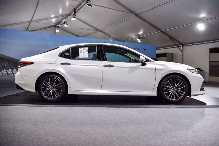 Ngoại thất của Toyota Camry 2022 bản 2.0Q được nâng cấp với đèn pha chiếu gần/xa loại LED/Bi-LED, mâm xe kích thước 18 inch. Bên trong cabin của chiếc sedan được bổ sung thêm lẫy chuyển số, vô-lăng chỉnh điện, cửa sổ trời, màn hình 9 inch hỗ trợ Apple CarPlay, điều hòa 3 vùng, lưng hàng ghế sau chỉnh điện, da cao cấp, sạc không dây và màn hình đa thông tin 7 inch.