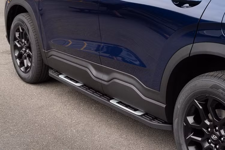 So với các phiên bản còn lại của dòng SUV 7 chỗ này, Hyundai SantaFe XRT thế hệ mới trông thể thao hơn nhờ nẹp thân xe bằng nhựa và tấm ốp bảo vệ gầm trước/sau màu xám. Thêm vào đó là lưới tản nhiệt màu đen nhám, ốp gương ngoại thất và baga nóc đều sơn màu đen. Ngoài ra, hãng Hyundai còn bổ sung bệ bước chân và bộ vành hợp kim 18 inch màu tối mới cho bản XRT này.