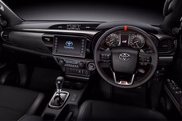 Về nội thất, Hilux Revo GR Sport sở hữu nội thất thể thao. Trong đó chìa khoá, vô lăng và tựa đầu ghế ngồi có logo “GR Sport”. Ghế bọc da kết hợp với da lộn và đường chỉ khâu màu đỏ.