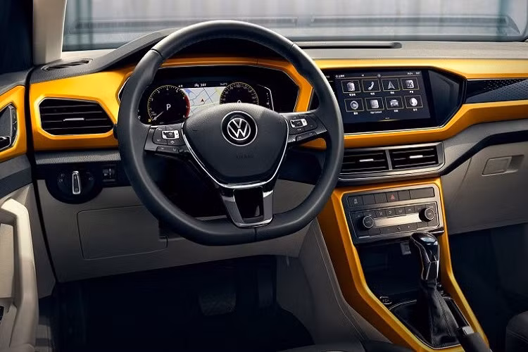 Trên cản trước xuất hiện 2 hốc đèn sương mù hình vuông khá lớn với viền mạ crôm sáng bóng. 2 hốc đèn sương mù này nằm trong khối màu đen hình khúc xương khiến nhiều người nhầm tưởng là hốc gió nhưng không phải. Hốc gió trung tâm thật của Volkswagen T-Cross 2021 nằm bên dưới khối màu đen này và đi kèm nẹp mạ crôm.