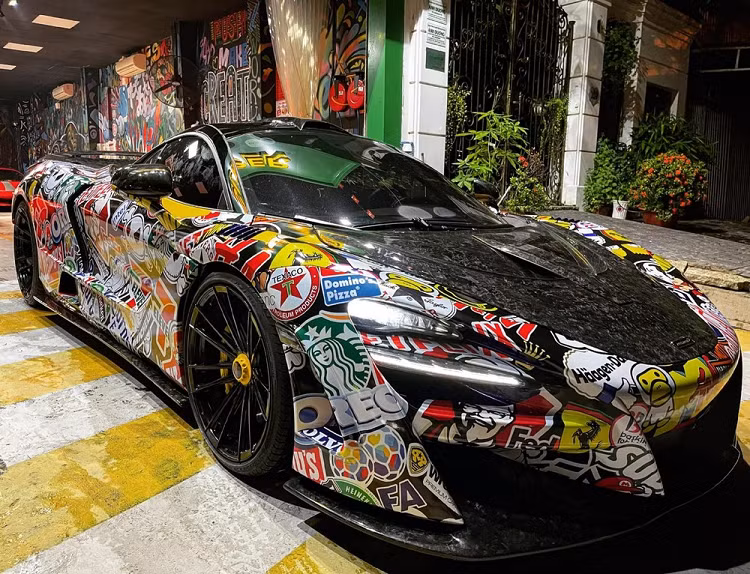 Chiếc xe được khoác lên mình bộ áo đề-can với điểm nhấn là nhiều thương hiệu nổi tiếng thế giới