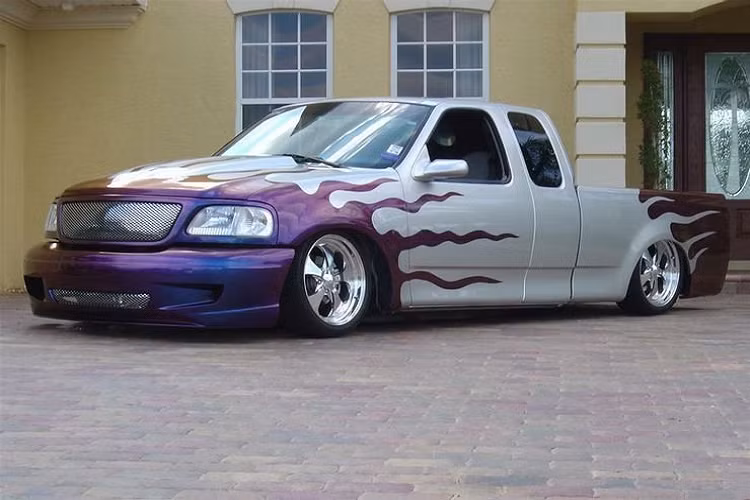 Bán tải "lùn": Chiếc xe được độ phần body-kit, mặt ca-lăng, đồng thời sơn lại theo hình ngọn lửa màu tím. Đáng nói, thợ độ đã hạ gầm một cách thô thiển, trông nó giống như một chiếc xe trong bộ phim hoạt hình dành cho các em nhỏ.