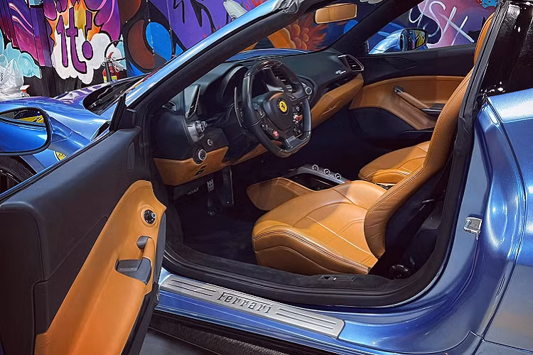 Nội thất bên trong xe Ferrari 488 Spider mới thay áo màu xanh nước biển có khoang lái màu da bò cùng với đó là nhiều chi tiết carbon. Được biết, so với những chiếc xe Ferrari 488 GTB, bên trong bảng điều khiển trung tâm của Ferrari 488 Spider sẽ có thêm 2 nút bấm, 1 nút là mở và đóng mui, nút còn lại là điều chỉnh kính chắn gió nhỏ đặt ngay chính giữa hai ghế ngồi của xe.