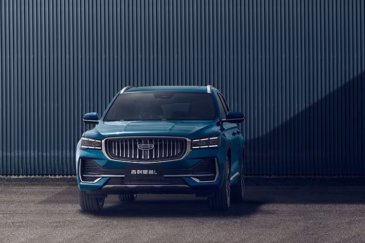 Trên đầu xe, Geely Xingyue L 2021 có lưới tản nhiệt cỡ lớn với những nan mạ crôm nằm dọc như thác nước và đèn pha Matrix LED hẹp, nằm giữa 2 dải đèn LED định vị ban ngày. Thêm vào đó là hốc gió trung tâm rộng, được bao quanh bằng nẹp mạ crôm sáng bóng, tấm ốp gầm giả màu bạc và 4 đường gân nổi bật trên nắp ca-pô.