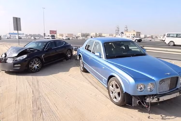 Tại Việt Nam, Bentley Arnage là mẫu xe siêu sang hàng hiếm, số lượng đếm trên đầu ngón tay. Ở Dubai, mẫu xe này không quá đặc biệt. Sau khi va chạm với Porsche Panamera, chiếc Arnage màu xanh dương bị chủ nhân để lại bên đường cao tốc ở Dubai. Theo truyền thông địa phương, 2 mẫu xe này nằm lại bên đường trong vài ngày trước khi được dời đi. Ảnh: cartoq.