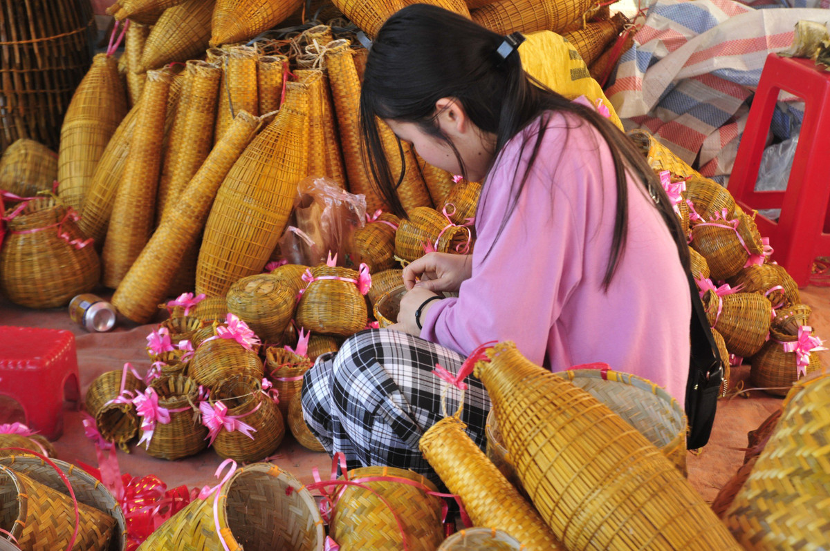 Một cô gái bán nông cụ tại chợ Viềng.