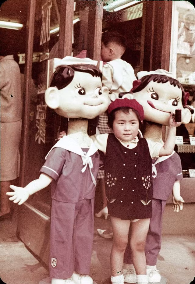 Bé gái chụp ảnh cùng Peko Chan, nhân vật biểu tượng của một nhãn hàng kẹo sữa Milky nổi tiếng Nhật Bản những năm 1950. Ảnh: Vintage Japan-esque.