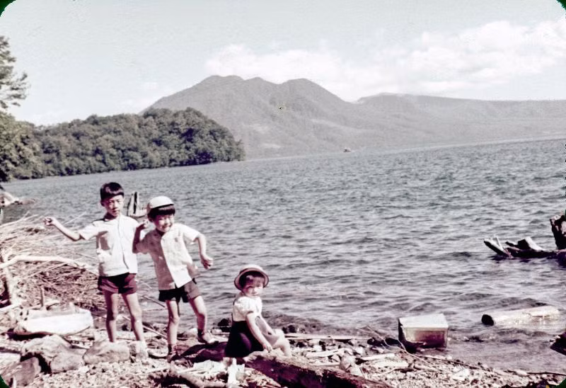 Hai chú bé ném đá xuống nước trong khi và cô bé nhìn vào ống kính máy ảnh. Ảnh: Vintage Japan-esque.