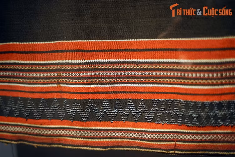  5. Dệt. Với kỹ thuật dệt, để tạo hoa văn, người ta thêm một sợi ngang khác biệt với sợi nền. Sợi ngang bổ sung này được chèn giữa làn sợi dọc theo hai kỹ thuật khác nhau: hoặc sợi chạy xuyên suốt chiều ngang khổ vải, hoặc chỉ ở vị trí dự định trang trí. Ảnh: Váy quấn dệt bằng vải bông của người Tà Ôi, Thừa Thiên Huế, 1984.