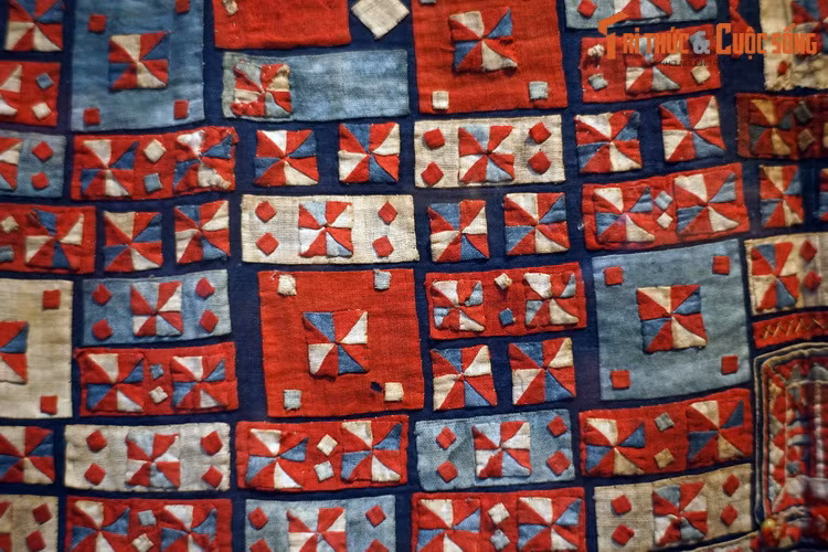  3. Đáp vải. Phổ biến ở một số tộc người miền núi phía Bắc, đáp vải là kỹ thuật tạo hoa văn bằng nhiều miếng vải màu nhỏ khâu trên một tấm vải nền. Vải để đáp có các màu khác nhau, được cắt hình tam giác, hình vuông, chữ nhật… rồi khâu đáp lên vải nền, mũi khâu giấu ở mặt sau không để lộ đường chỉ. Ảnh: Khăn có hoa văn đáp vải của người Pu Péo, Hà Giang, 1979.