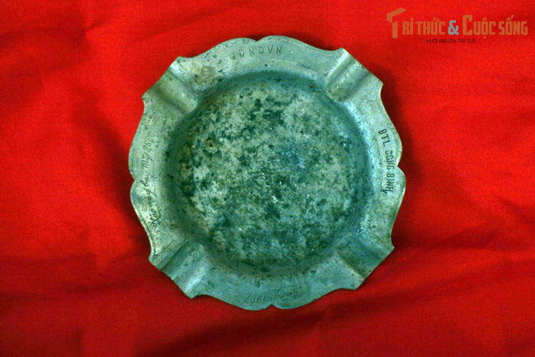 Chiếc gạt tàn này làm từ xác máy bay Mỹ, có khắc dòng chữ: “Xác máy bay thứ 2.600″,”QĐNDVN” (Quân đội Nhân dân Việt Nam), “BTLCB” (Bộ Tư lệnh Công binh).