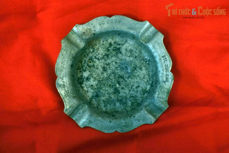 Chiếc gạt tàn này làm từ xác máy bay Mỹ, có khắc dòng chữ: “Xác máy bay thứ 2.600″,”QĐNDVN” (Quân đội Nhân dân Việt Nam), “BTLCB” (Bộ Tư lệnh Công binh).