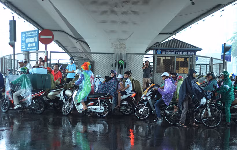 Do mưa to nên một số người không thể di chuyển được đành tìm mọi nơi trên đường có thể trú mưa.