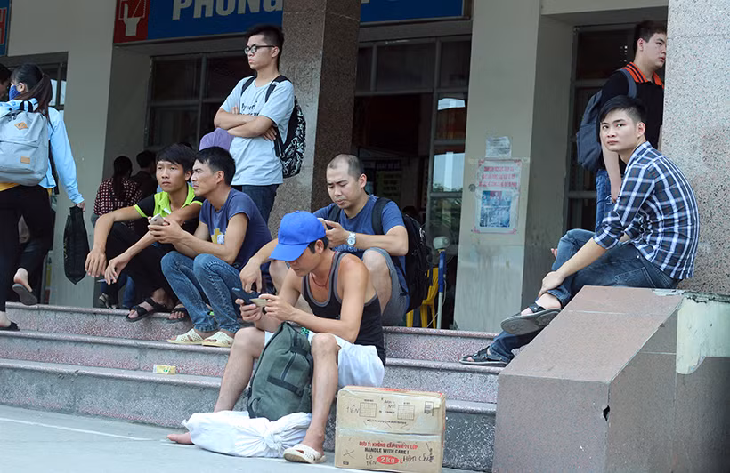 Do lượng người phía trong khu vực bán vé phải xếp hàng đông nên một số người tranh thủ ngồi vật vạ ngoài hành lang bến Mỹ Đình đợi chờ đến lượt.