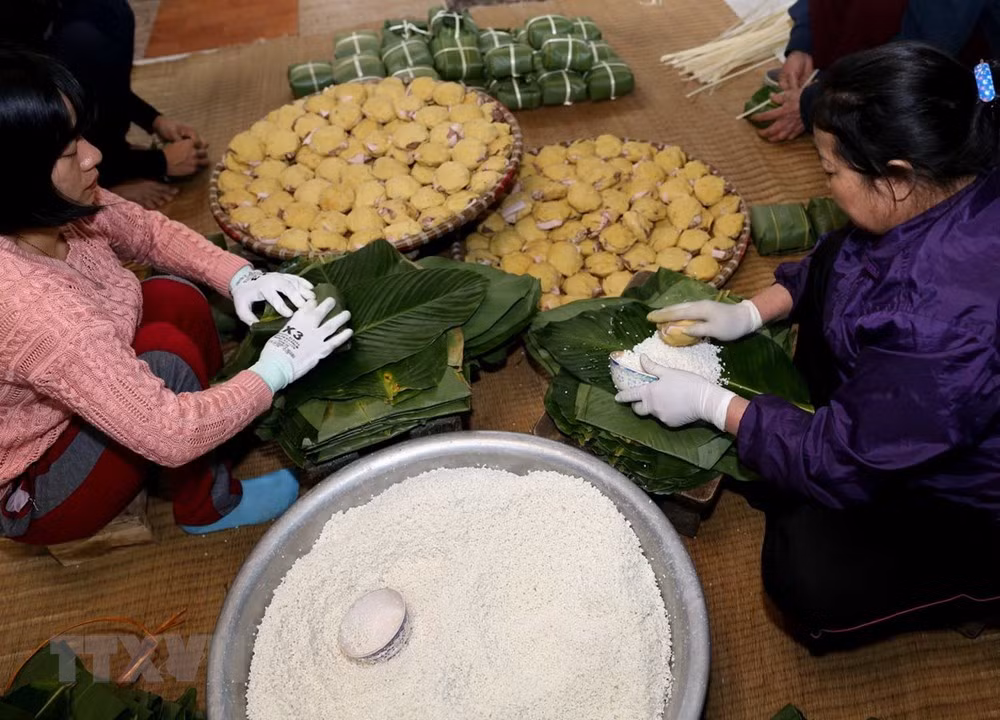 Gói bánh tại gia đình chị Nguyễn Thị Hường, làng Tranh Khúc. (Ảnh: Vũ Sinh/TTXVN)