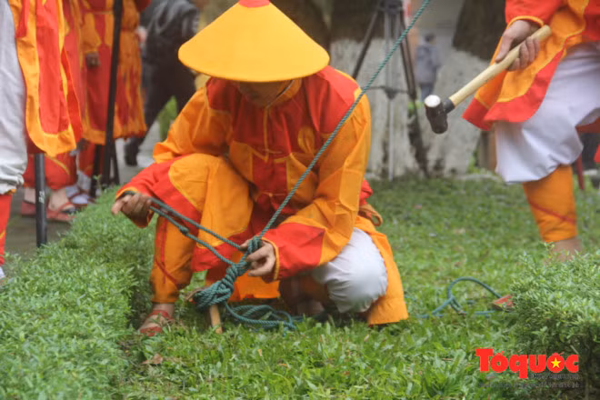 Lính vệ đóng cọc néo dây để cây nêu đứng vững trong những ngày Tết cổ truyền.