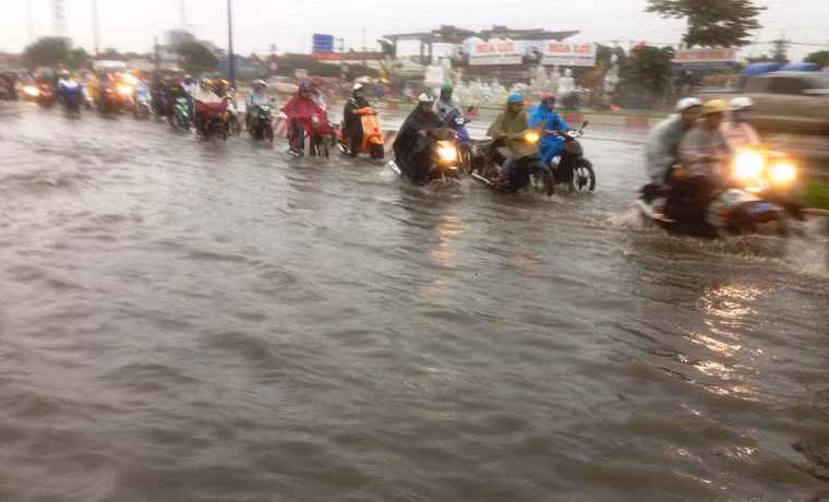Trong và sau cơn mưa, nước ngập sâu gần nửa mét khiến hàng vạn phương tiện vô cùng khổ sở bì bõm lội trong nước.