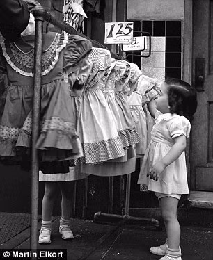 Bé gái thích thú khi ngắm nhìn những mẫu váy dễ thương được bày bán trên vỉa hè ở New York.