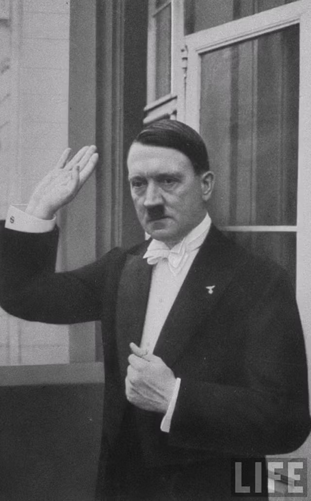 Trùm phát xít Hitler lịch lãm trong bộ vest sang trọng vẫy tay tạm biệt mọi người sau khi dự tiệc mừng năm mới tại Berlin năm 1936.