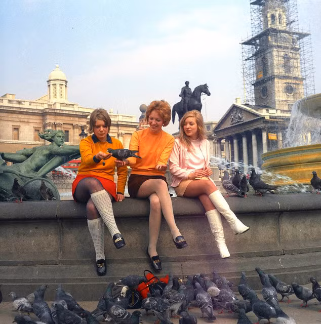 Nhóm thiếu nữ London cho chim bồ câu ăn khi ngồi chơi tại Quảng trường Trafalgar.