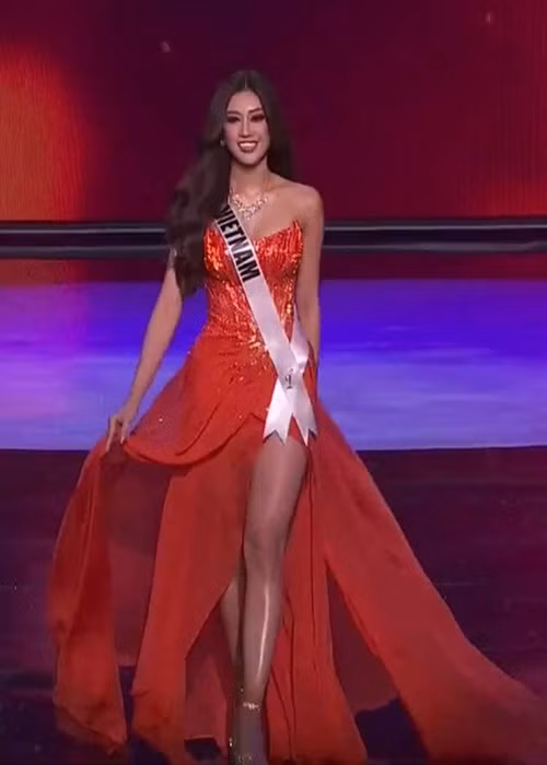 Bước sang phần thi trình diễn trang phục dạ hội, đại diện Việt Nam diện váy màu cam cúp ngực, xẻ tà cao bay bổng.