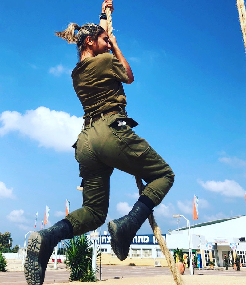 Vóc dáng hầm hố nhưng không kém phần gợi cảm của một nữ quân nhân Israel trong quá trình tập đu dây trên thao trường.