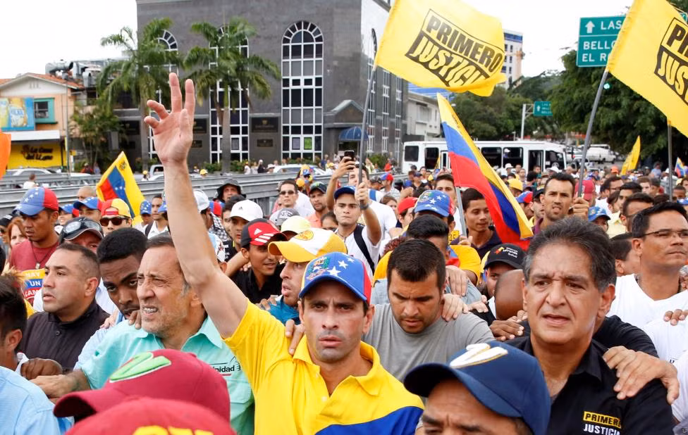 Thủ lĩnh đảng đối lập và Thống đốc bang Miranda Henrique Capriles (ở giữa) tham gia vào cuộc biểu tình ở Caracas hôm 26/10.