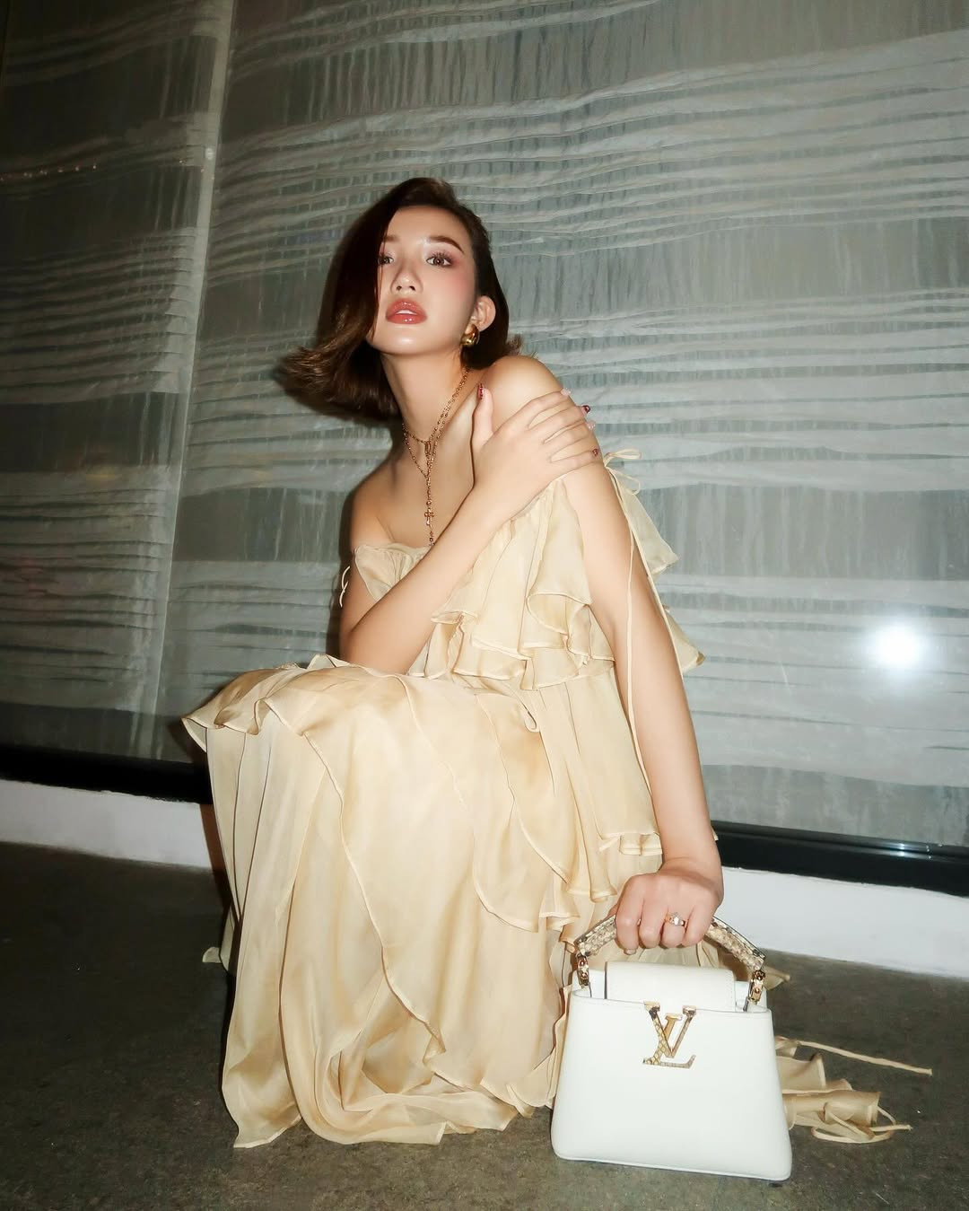 Trong loạt ảnh trước đó không lâu, Huyền 2k4 diện thiết kễ váy xếp tầng bay bổng, kết hợp cùng thiết kế túi LV đắt đỏ.