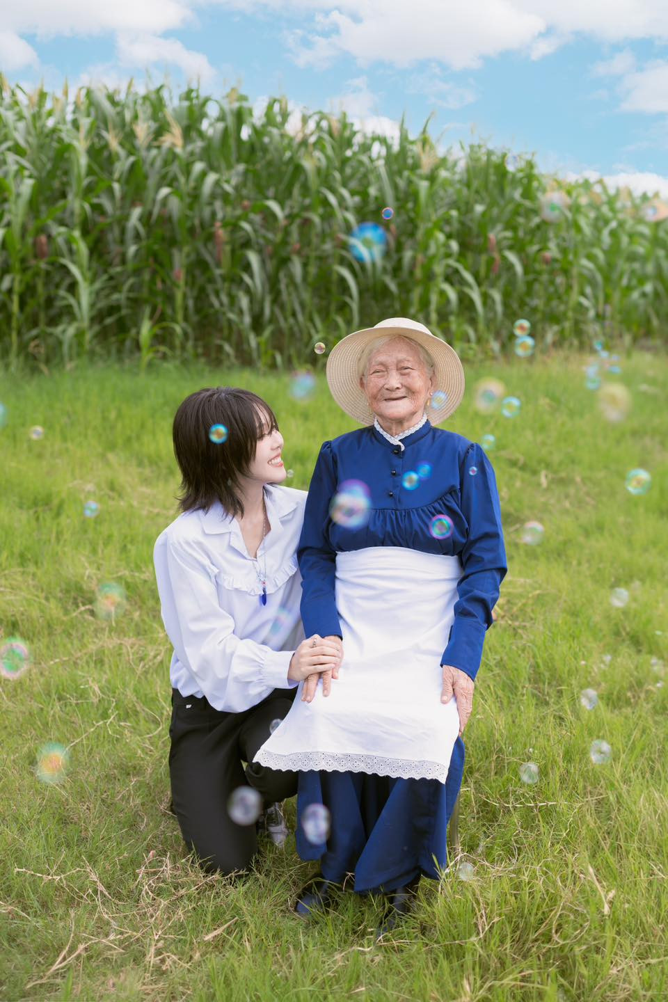 Cô nàng cũng bà nội mình lấy bối cảnh đồng quê với bãi cỏ xanh mướt mắt, phía sau là ruộng ngô tươi tốt. Khung cảnh bình yên rất Việt Nam làm nền cho bà - cháu đem đến cảm giác ấm áp, gần gũi.