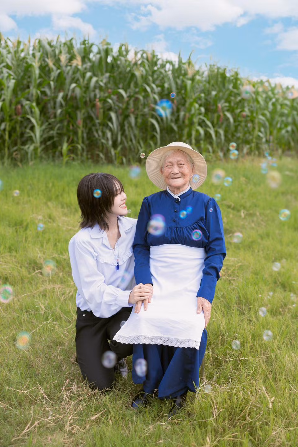 Cô nàng cũng bà nội mình lấy bối cảnh đồng quê với bãi cỏ xanh mướt mắt, phía sau là ruộng ngô tươi tốt. Khung cảnh bình yên rất Việt Nam làm nền cho bà - cháu đem đến cảm giác ấm áp, gần gũi.