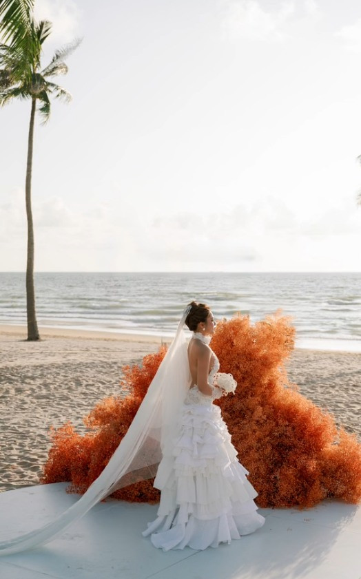 Trong đám cưới của mình, Minh Thư và Hoàn Hảo diện nhiều trang phục, thay nhiều concept khác nhau. Ngoài bó hoa ngọc trai thì cô nàng cũng gây chú ý với những mẫu hoa cưới lạ mắt khác như hoa lan làm thành vòng tròn rũ xuống, hoa hồng đỏ hay hoa vàng cho phù dâu,... (Ảnh: FBNV)