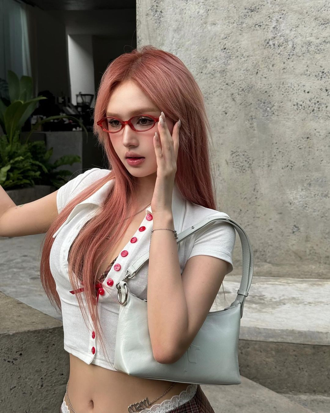 Nàng hot girl hoàn thiện set đồ với chiếc kính oval màu đỏ đậm hơi thở Y2K.