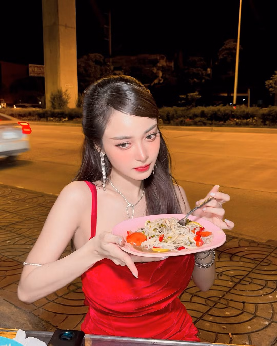 Trong loạt ảnh tạo dáng bên xe đồ ăn đêm, cô nàng diện chiếc váy đỏ làm tôn lên nước da trắng sứ, khoe dáng với đường cong cực nóng bỏng.