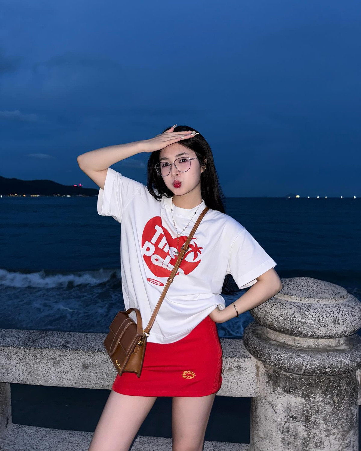 Trong chuyến đi biển này, cô nàng cũng lựa chọn outfit khác năng động hơn với áo phông trắng và chân váy ngắn màu đỏ nổi bật.