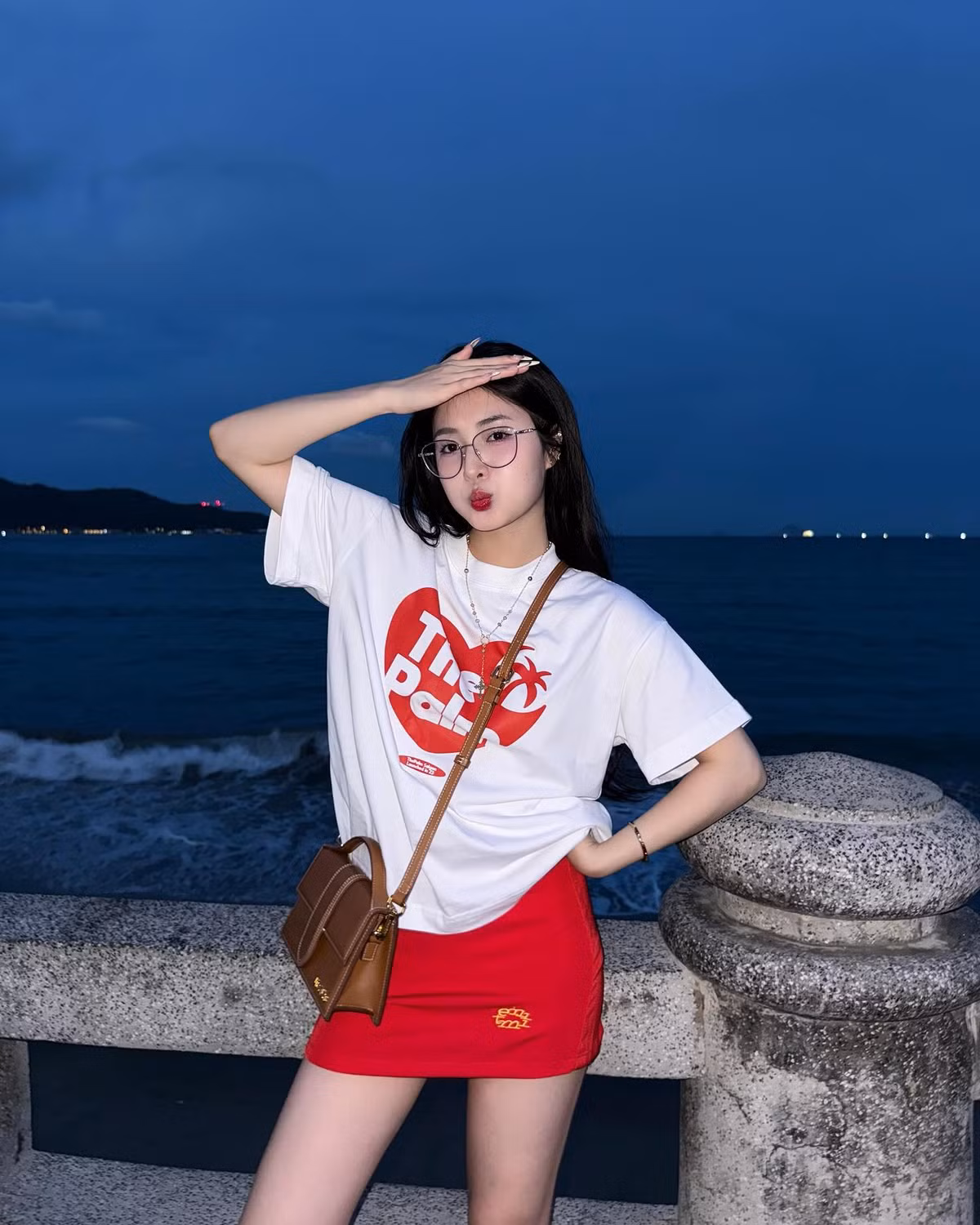 Trong chuyến đi biển này, cô nàng cũng lựa chọn outfit khác năng động hơn với áo phông trắng và chân váy ngắn màu đỏ nổi bật.