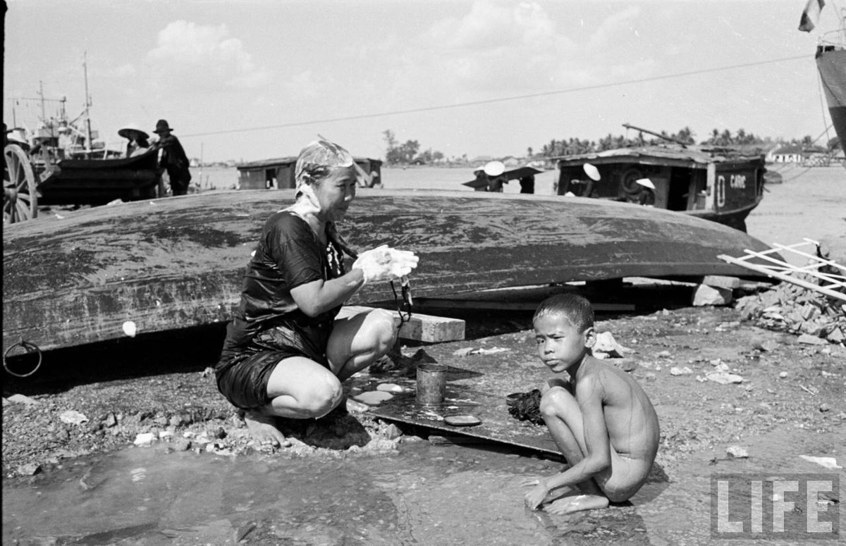 Cảnh tắm gội của dân xóm chài bên bờ sông. Nguồn nước phục vụ sinh hoạt là nước sông, lúc này vẫn còn rất sạch. Ảnh: Carl Mydans/ Life.