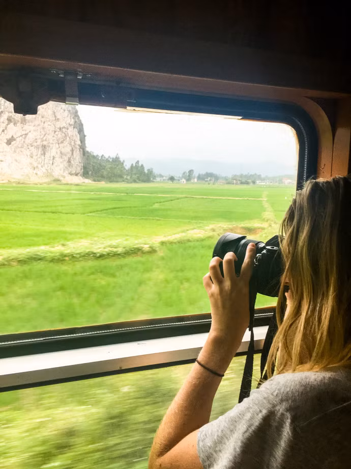 "Từ Huế đến Ninh Bình, chúng tôi đi tàu đêm trong một cabin 4 giường mềm. Tôi đã không ngủ được nhiều vì chuyến tàu vẫn dừng lại suốt đêm. Khá ồn ào, nhưng nhìn chung là thoải mái. Khi thức dậy, cả cabin chỉ còn chúng tôi và thật tuyệt khi ngồi và ngắm phong cảnh". Ảnh: Almost Landing.