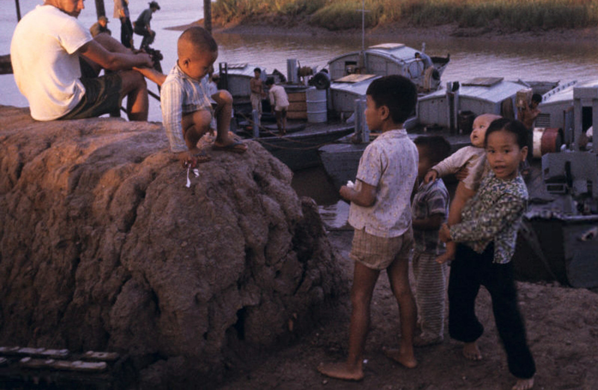 Những đứa trẻ chơi đùa bên bờ sông Mekong, gần những chiếc ca nô quân sự, 1965. Ảnh: Jean-Claude Sauer.