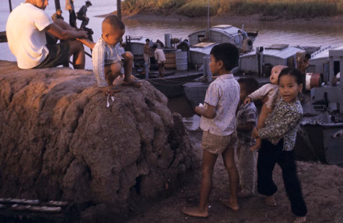 Những đứa trẻ chơi đùa bên bờ sông Mekong, gần những chiếc ca nô quân sự, 1965. Ảnh: Jean-Claude Sauer.